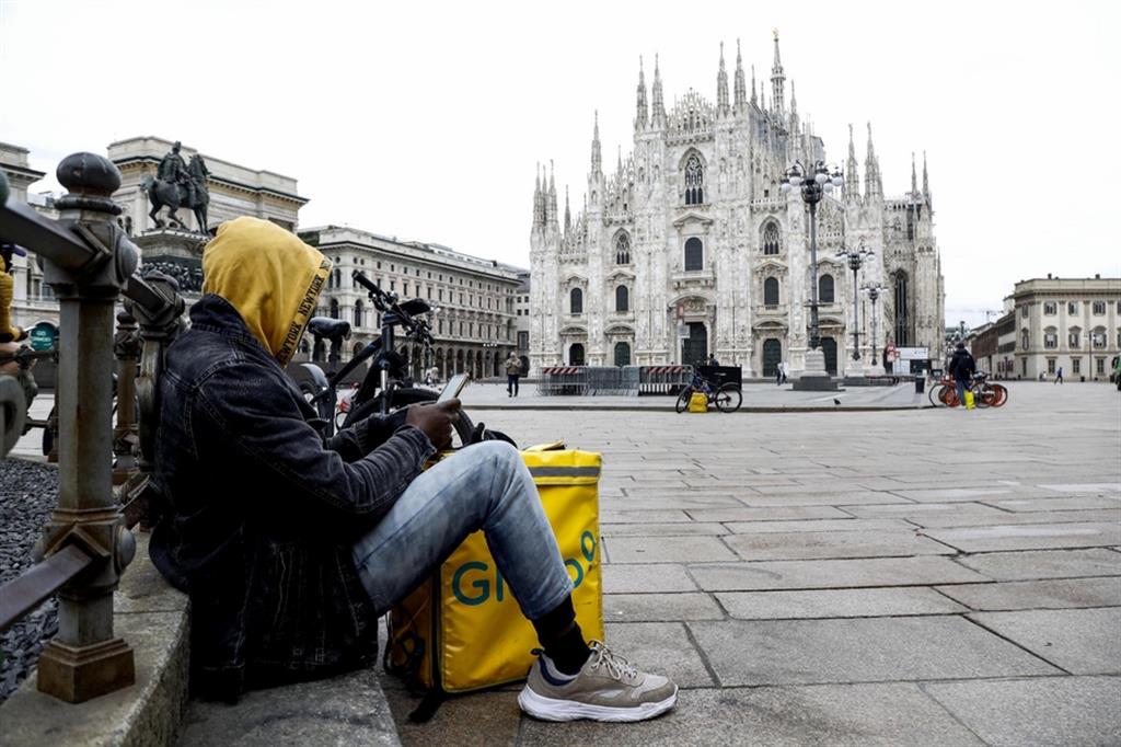 Rider in attesa di ordinazioni in piazza Duomo, a Milano, nei giorni del lockdown