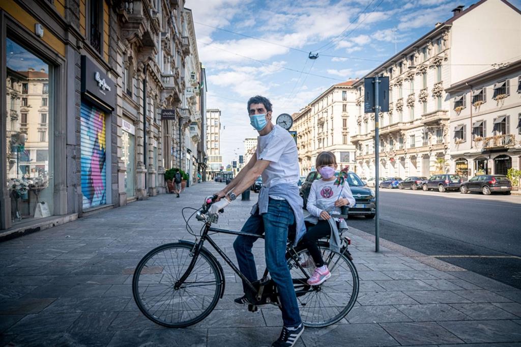 Un papà con la sua bambina in bici per le vie del centro di Milano