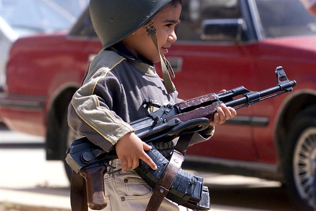Un bambino soldato armato di kalashnikov in Iraq nel 2003
