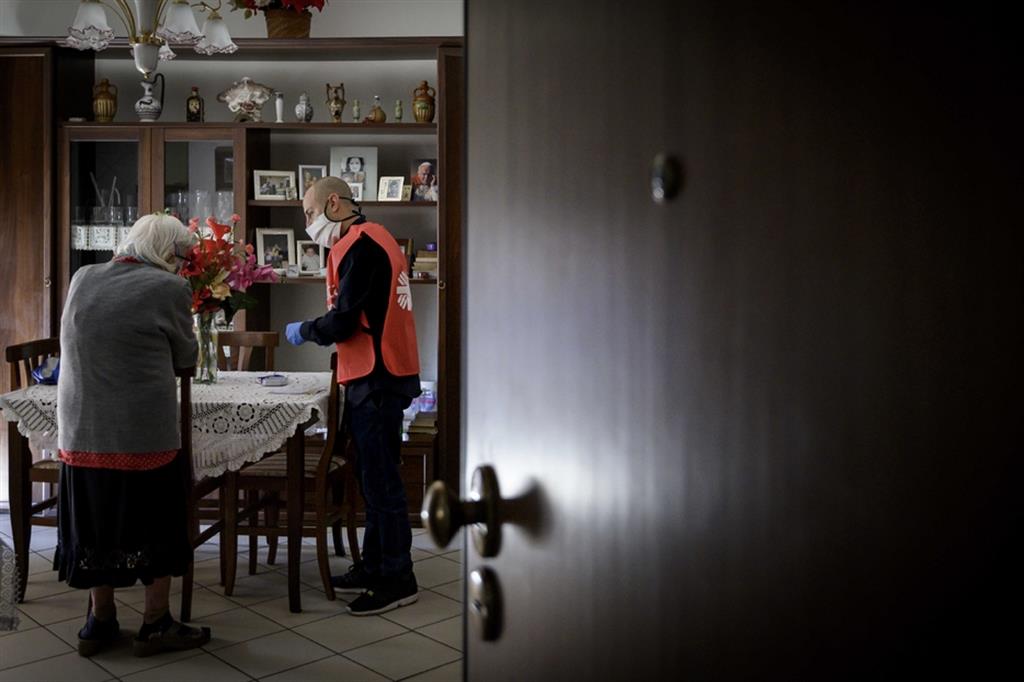 Un volontario della Caritas porta la spesa ad una persona anziana costretta in casa dalla pandemia di Coronavirus
