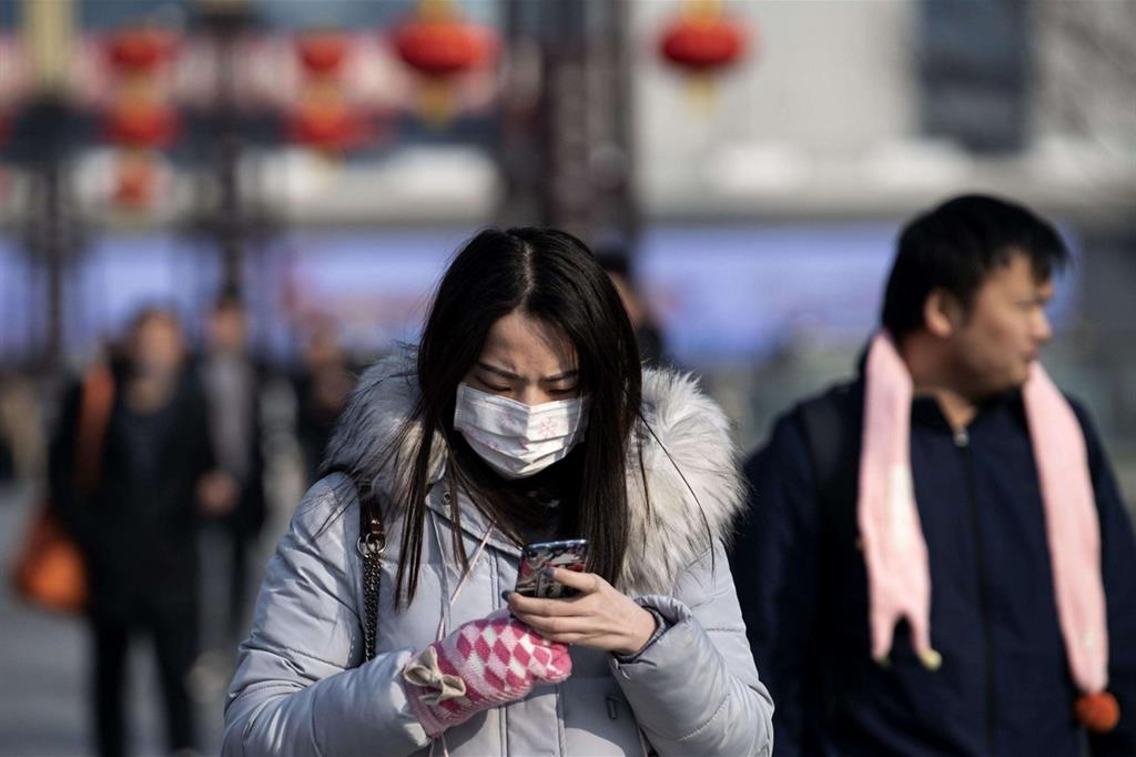 Una donna munita di mascherina nella stazione di Hanzhong, in Cina
