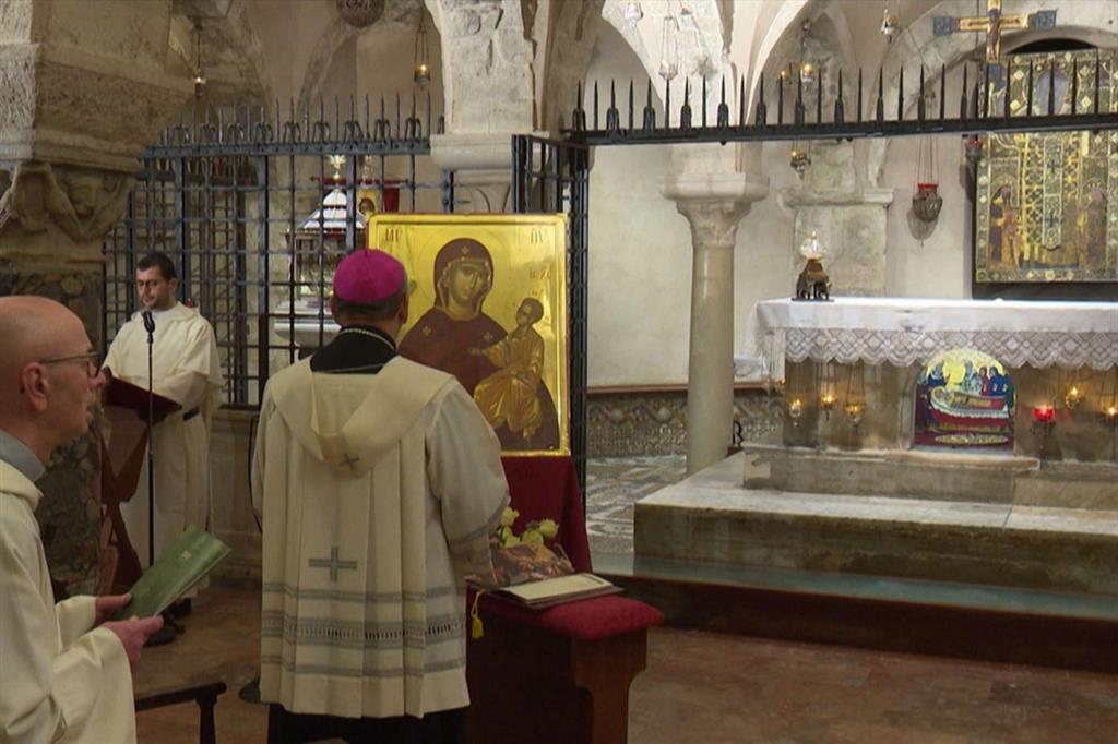 Monsignor Cacucci si inchina davanti all'icona della Madonna nella Cripta della Basilica di San Nicola a Bari durante il Rosario per l'Italia