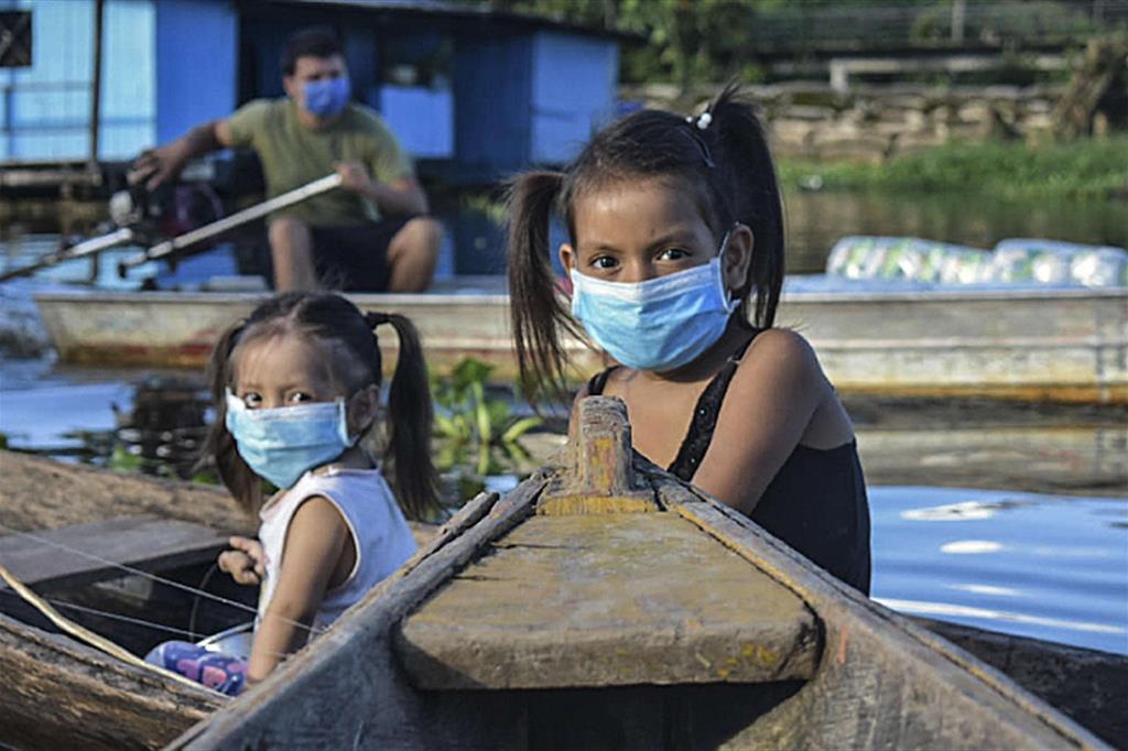 Due bambine con le mascherine anti Covid-19 lungo il Rio delle Amazzoni a Leticia, in Colombia