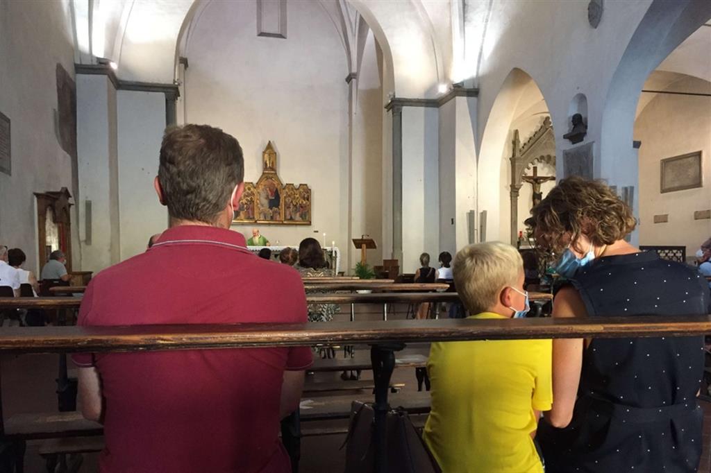 Una famiglia che partecipa alla Messa in una parrocchia italiana seguendo le misure anti-Covid