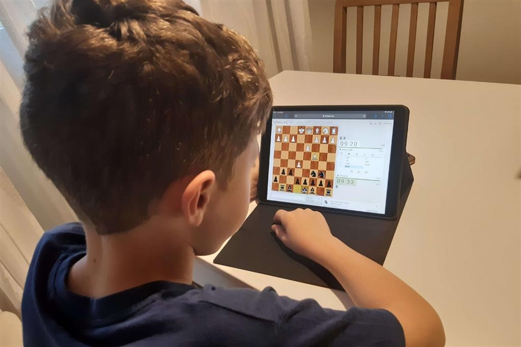 Un giovanissimo giocatore di scacchi impegnato on line