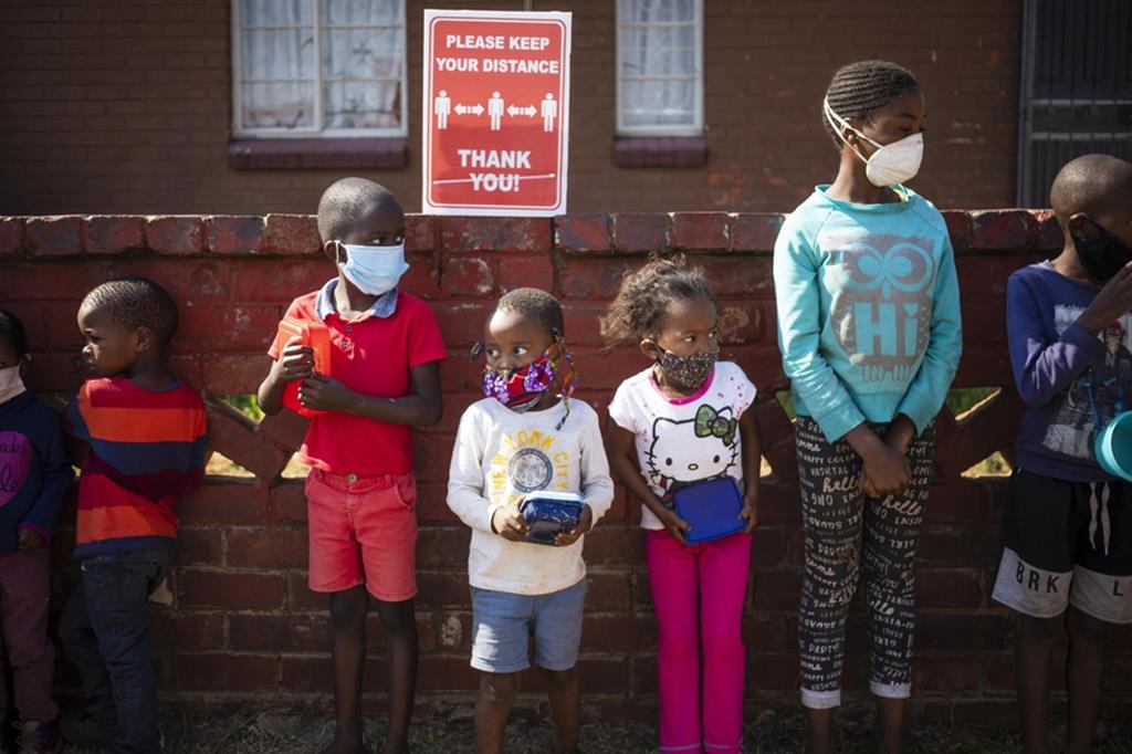 Bambini in fila a Johannesburg, Sudafrica, per ricevere aiuti alimentari