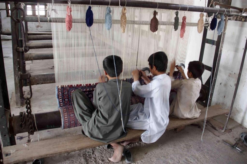 Alcuni ragazzini pachistani che lavorano nella fabbricazione dei tappeti