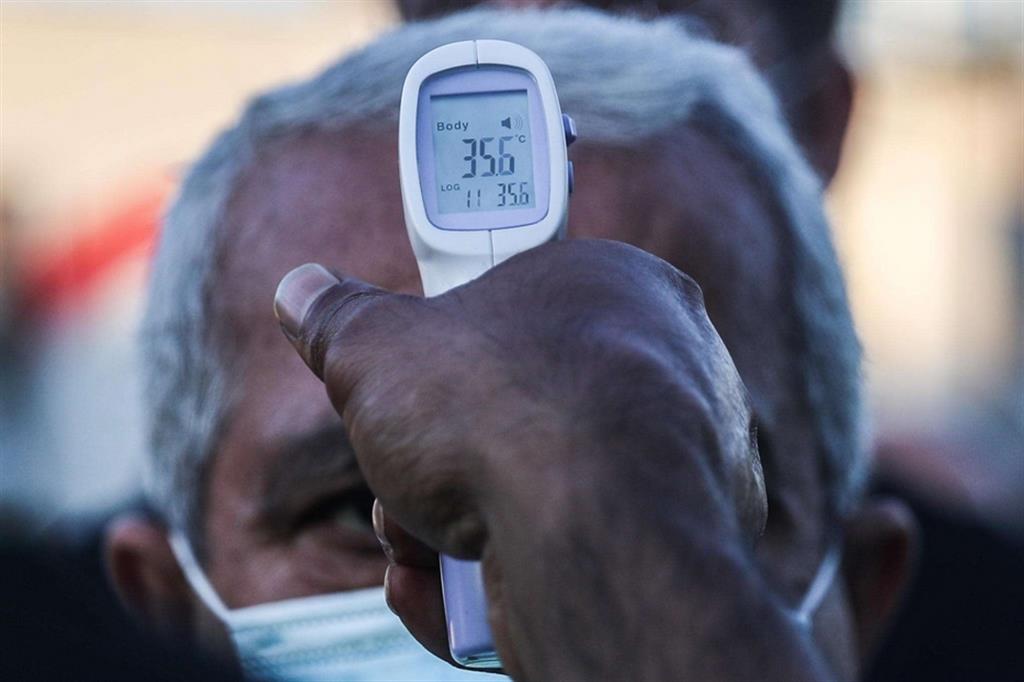 Volontario misura la temperatura di un fedele musulmano durante la festa di "Eid al-Adha"