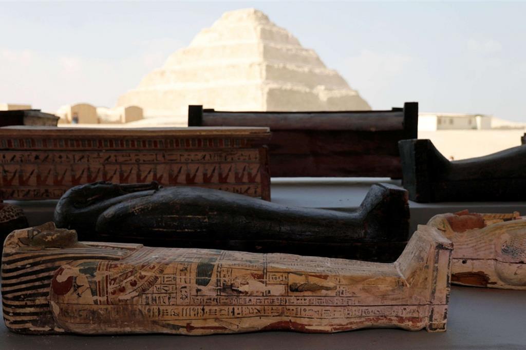 Alcuni dei sarcofagi ritrovati nelle scorse settimane a Saqqara, in Egitto. Sullo sfondo, la piramide a gradoni