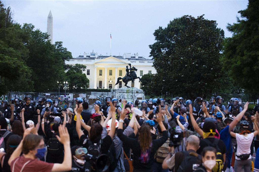Manifestanti alzano le mani mentre la polizia fa sgombrare piazza Lafayette