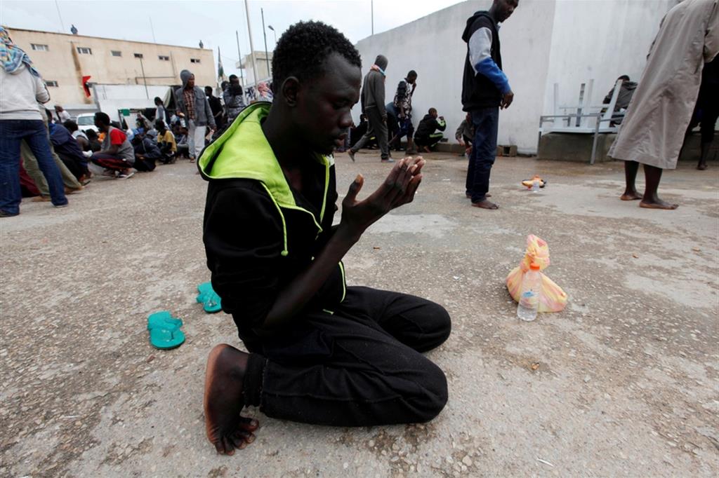 La preghiera. Un profugo rinchiuso in un campo di detenzione libico a Tripoli