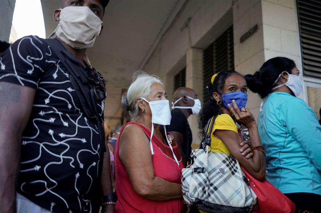 Cubani in fila per il cibo, con la mascherina. La pandemia di Covid-19 è arrivata anche sull'isola dei Caraibi