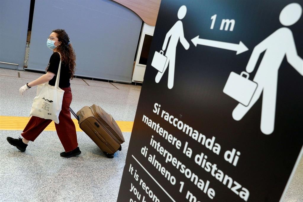 Una passeggera, con mascherina, in transito all’aeroporto di Roma Fiumicino. Con la ripresa (parziale) dei voli aumentano i controlli