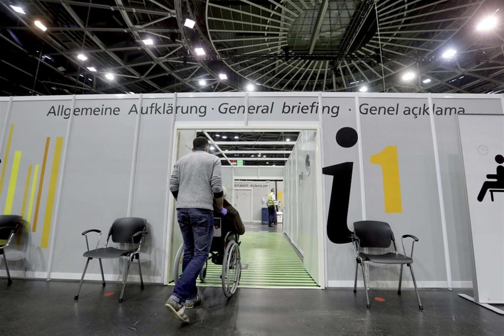 Un disabile accompagnato a vaccinarsi al Velodromo di Berlino, trasformato in hub per le immunizzazioni