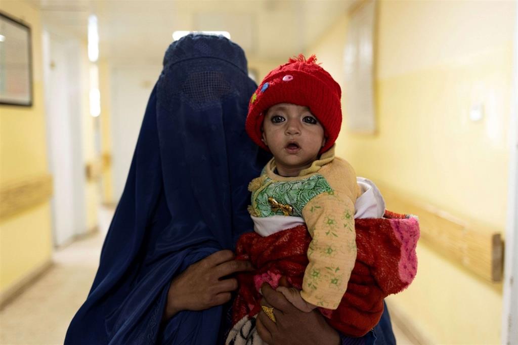 Una donna in burqa nel corridoi del reparto di malnutrizione infantile all'ospedale Indra Gandhi di Kabul - Reuters