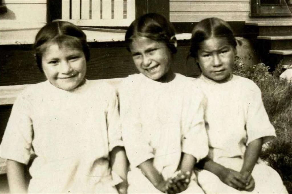 Foto d'epoca di tre bambine delle Prime Nazioni in un pensionato di Saskatchewan sul cui terreno sono state ritrovate tombe comuni di bambini