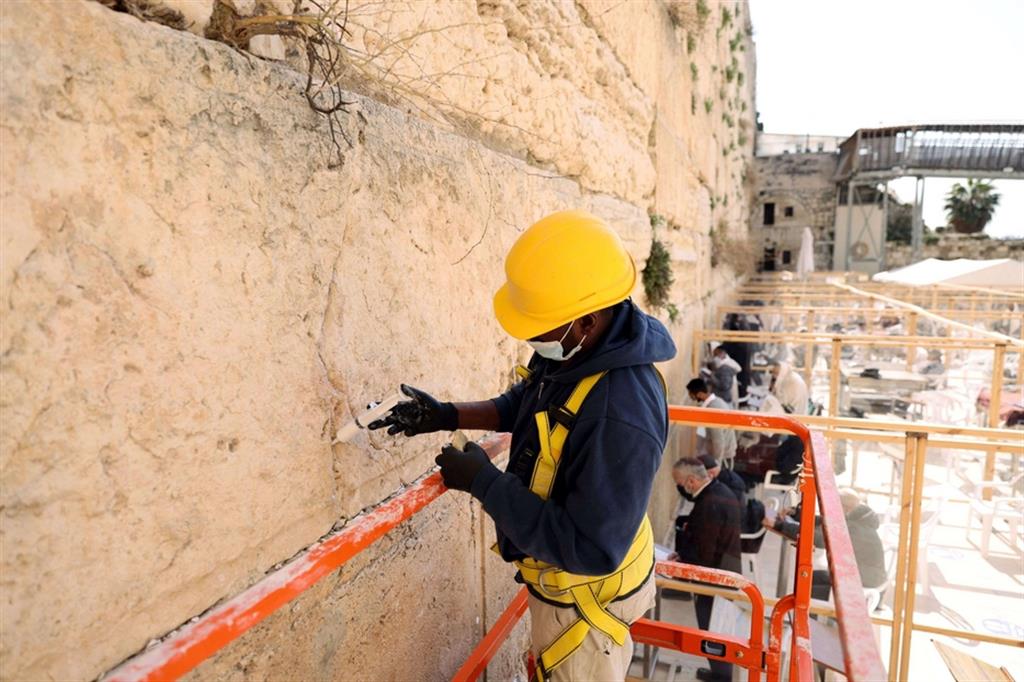 Una soluzione a base calcarea viene inserita tra le pietre del Muro Occidentale a Gerusalemme
