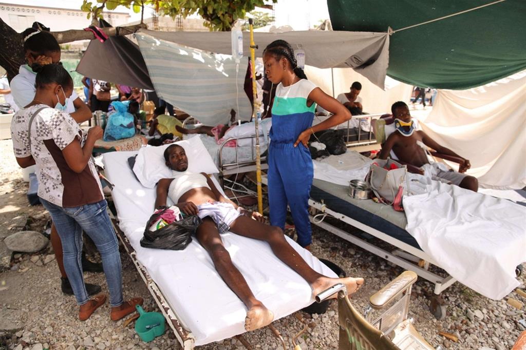 Feriti sistemati su letti di fortuna fuori dall'ospedale di Les Cayes, Haiti