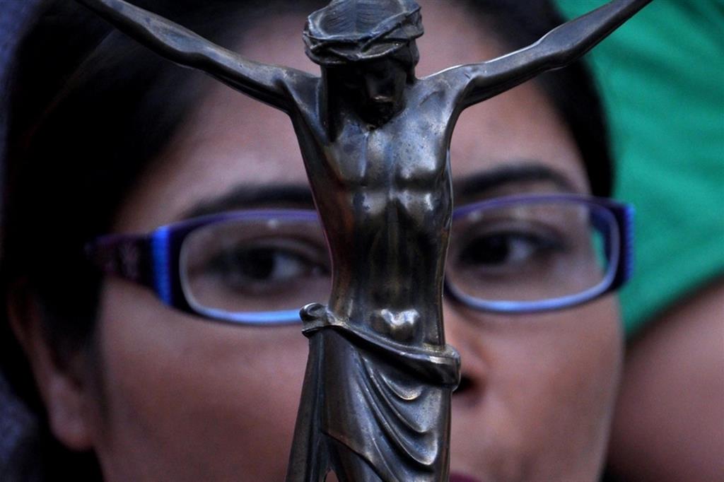 Una donna pachistana porta il Crocifisso a una manifestazione di sostegno ai cristiani perseguitati