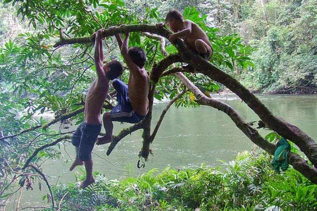 Bambini Shuar giocano lungo il fiume nella selva