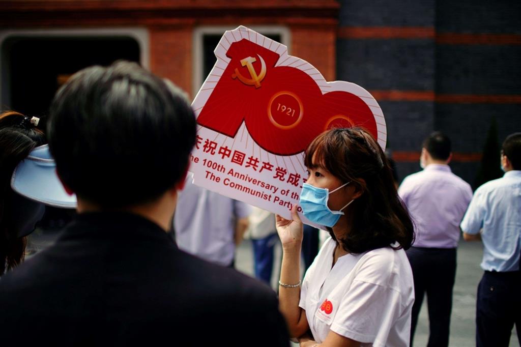 Una donna a Shanghai con un cartello che ricorda i cent’anni della nascita del Pcc, in occasione di una mostra al Memoriale del I Congresso Nazionale del Partito Comunista Cinese