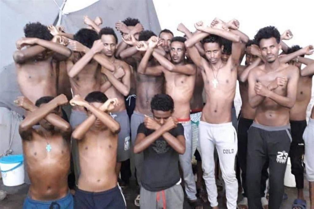Un gruppo di migranti detenuti in un campo libico. Spesso si punta ad ottenere un riscatto per poi metterli in mare su un barcone insicuro