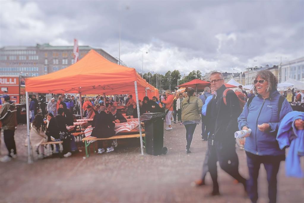 Persone al mercato di Helsinki sotto un cielo pieno di nubi
