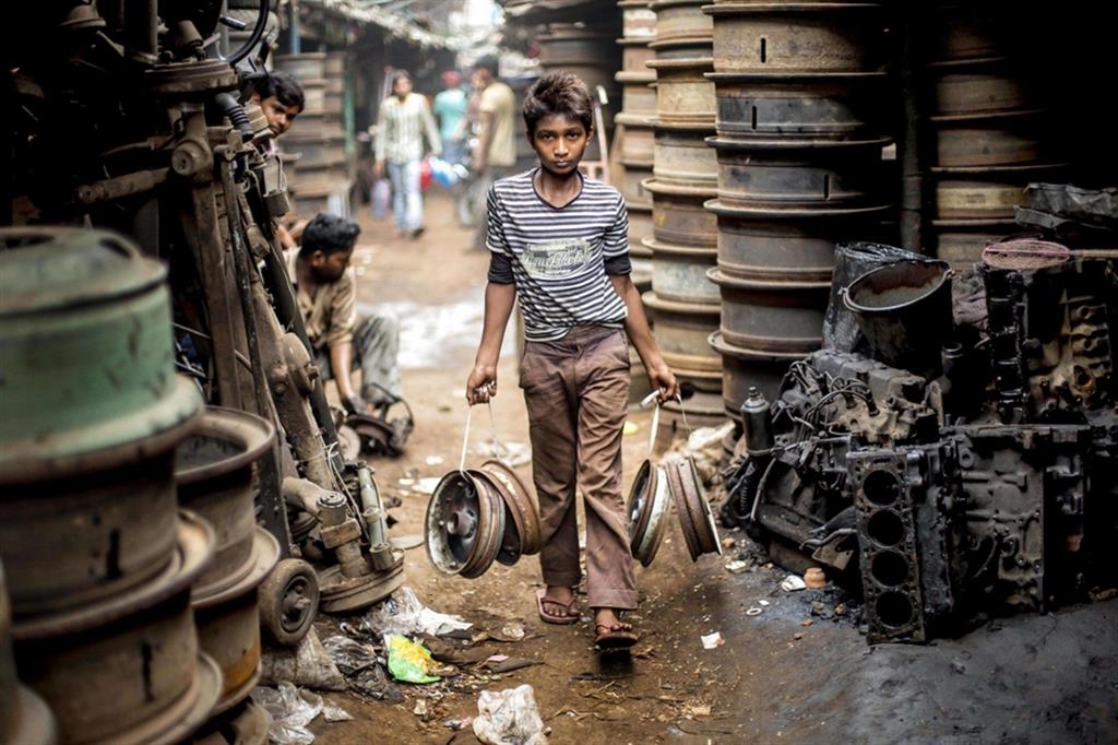 Un ragazzo in un deposito di pezzi di ricambio a Calcutta in India