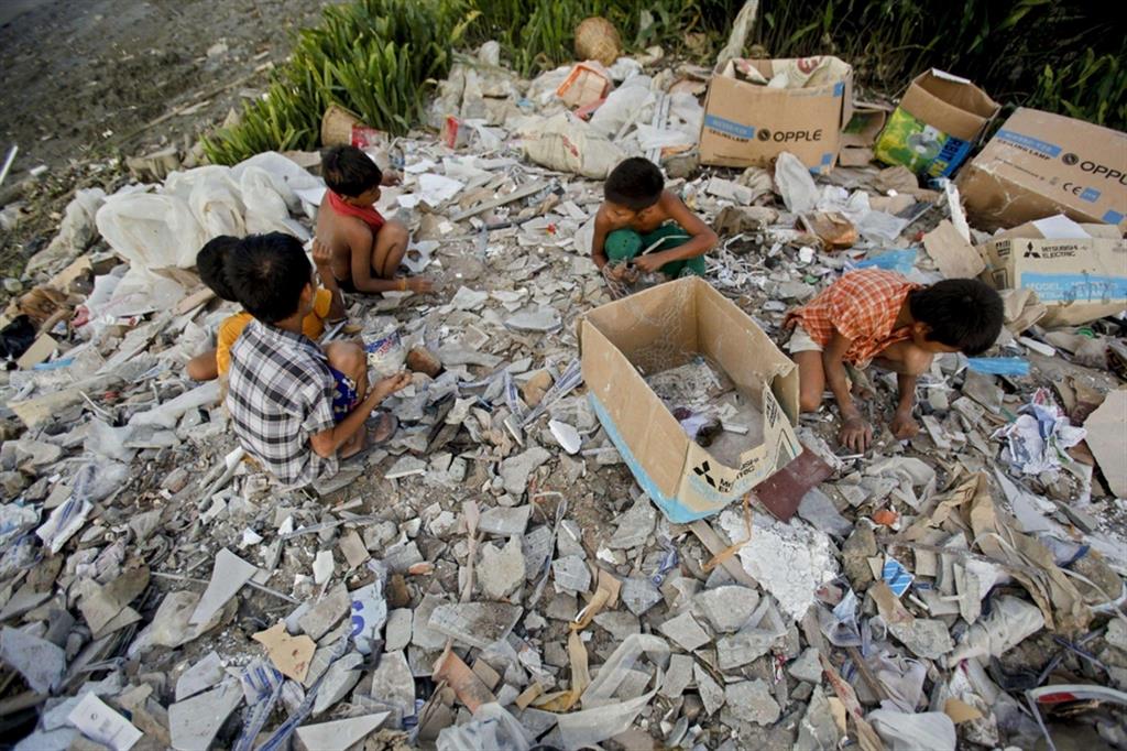 Bambini raccolgono rifiuti nei sobborghi di Yangon. Almeno 75 sono stati uccisi dalla giunta militare responsabile del colpo di stato dello scorso febbraio