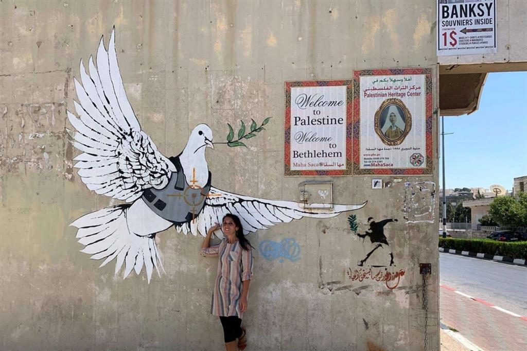 Pina Belmonte sotto la colomba disegnata da Banksy a Betlemme