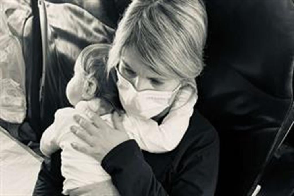 La pediatra della Croce Rossa coccola la piccola "Serenella" nel viaggio verso l'Italia