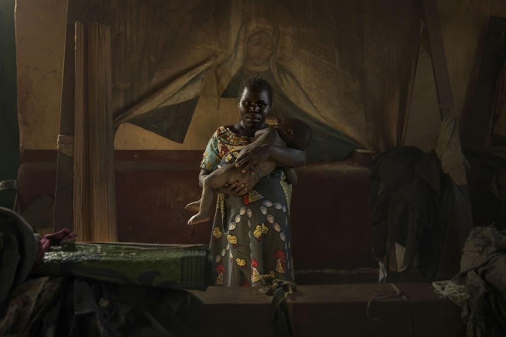Repubblica Democratica del Congo, Drodro. Christine, 30 anni, con in braccio il suo bambino. Il suo villaggio è stato attaccato dai ribelli. Christine è corsa via con i suoi sette figli, trovando rifugio nella vecchia chiesa - © Newsha Tavakolian / Magnum Photos