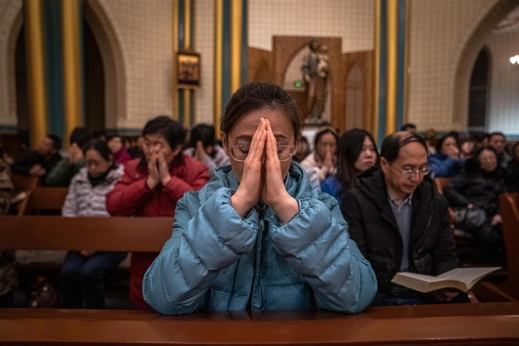 Fedeli cattolici in preghiera in una chiesa di Pechino