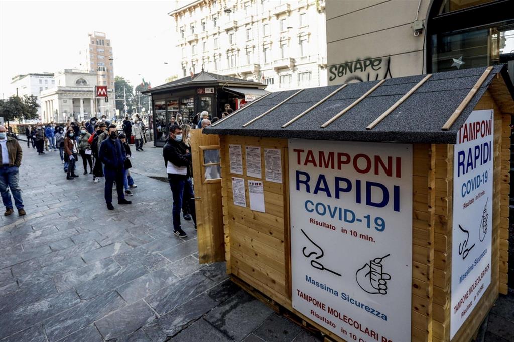 Persone in coda per il test del tampone rapido davanti a una farmacia in porta Venezia a Milano