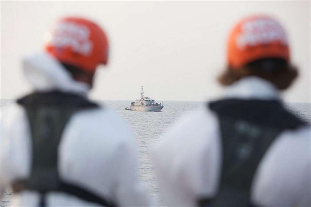 Due volontari di Resq osservano l'intervento della motovedetta libica a danno dei migranti