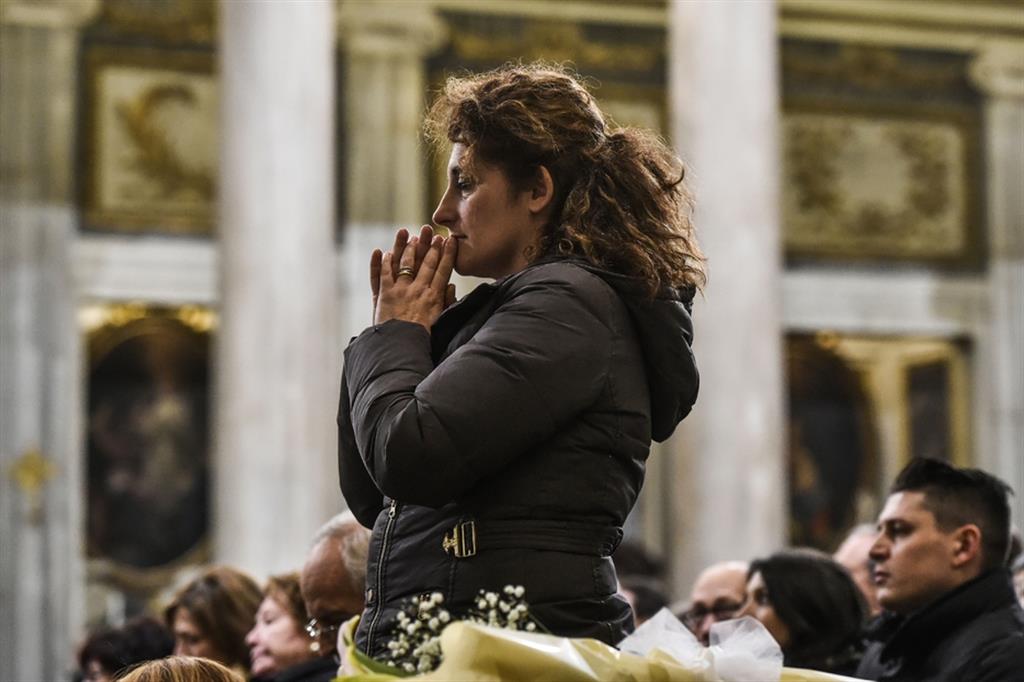 Una donna in preghiera in chiesa