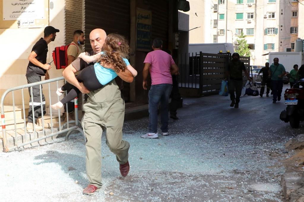 Beirut. Un uomo in fuga con una bambina subito dopo l'inizio della sparatoria