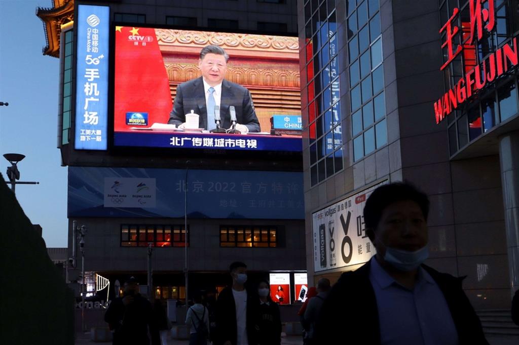Xi Jinping, su un maxi-schermo a Pechino, durante il summit sul clima con Angela Merkel ed Emmanuel Macron
