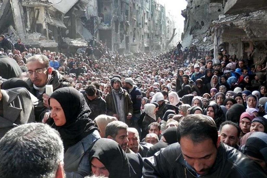 I profughi, in prevalenza palestinesi, in fila per il cibo durante l’assedio del campo di Yarmuk alle porte di Damasco, il 31 gennaio 2014