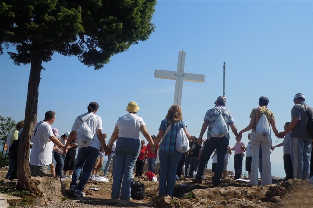 Un gruppo di pellegrini si tiene per mano sul Krizevac, il monte della Croce, a Medjugorje