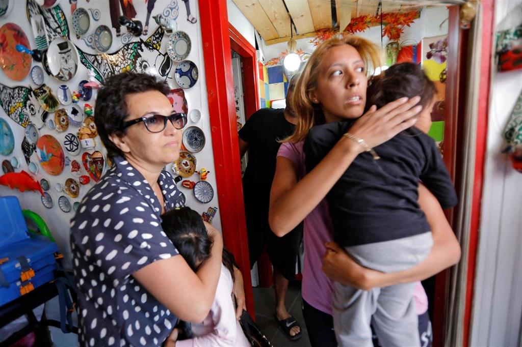 Due donne israeliane con i figli cercano riparo in un negozio di Tel Aviv