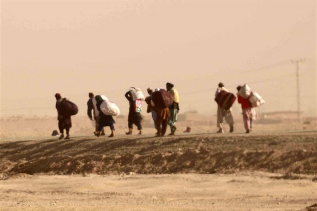 Profughi afghani in fuga camminano verso il confine con il Pakistan, sperando che la frontiera venga riaperta