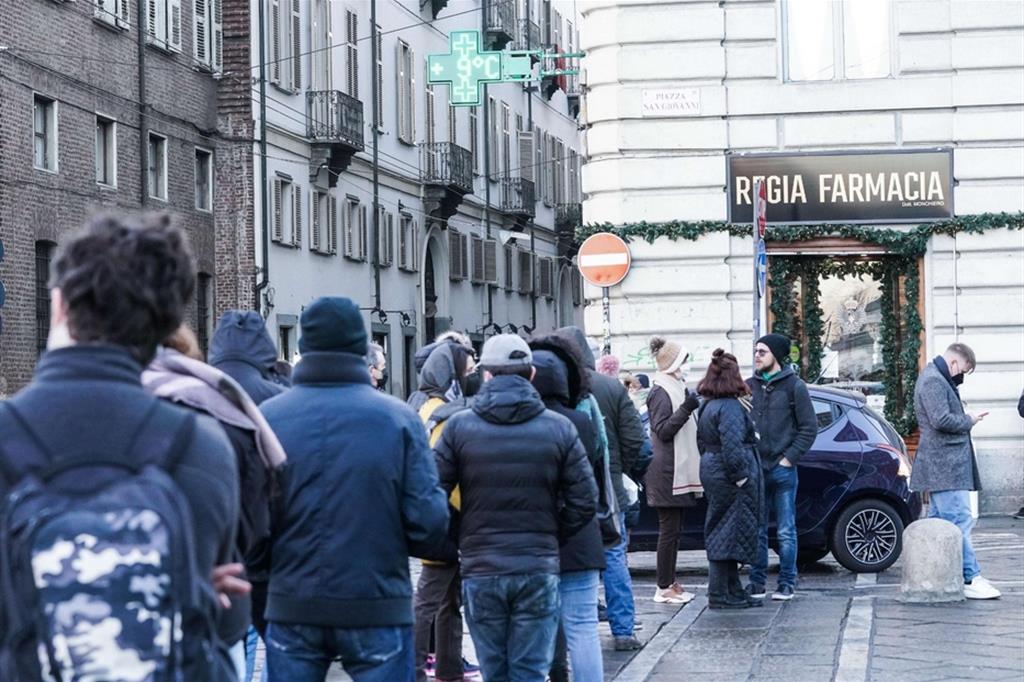 Persone in fila davanti ad una farmacia per effettuare un tampone antigienico a Torino