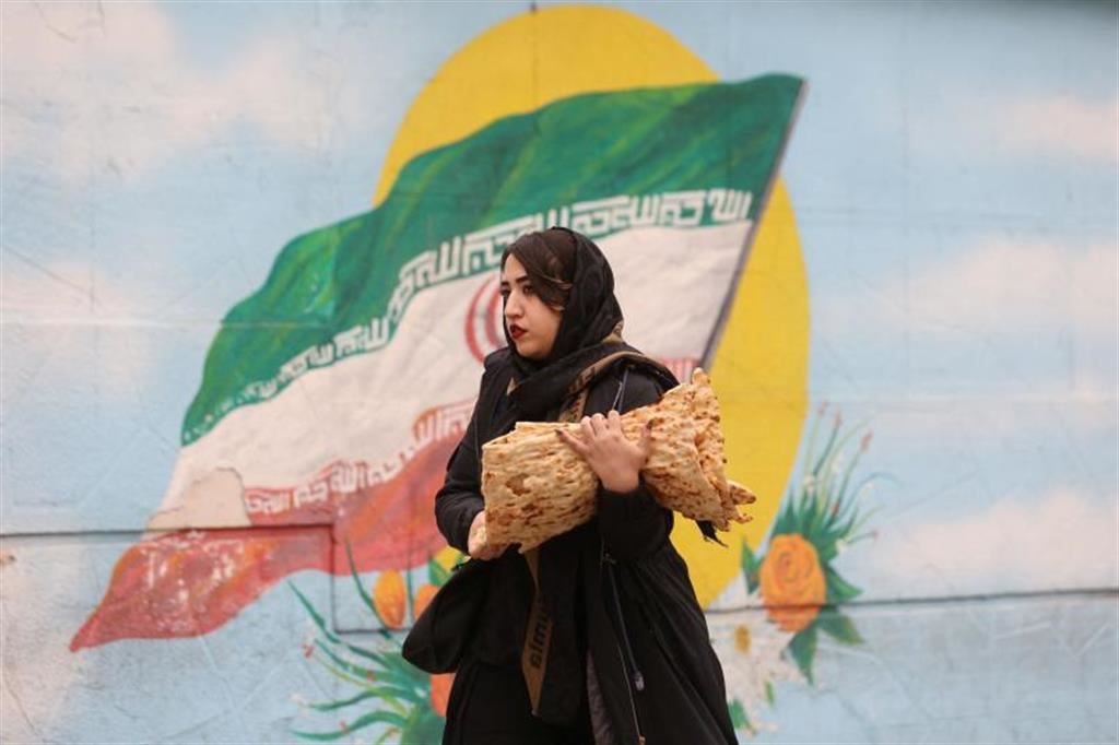 Una donna con il velo cammina per le vie di Teheran