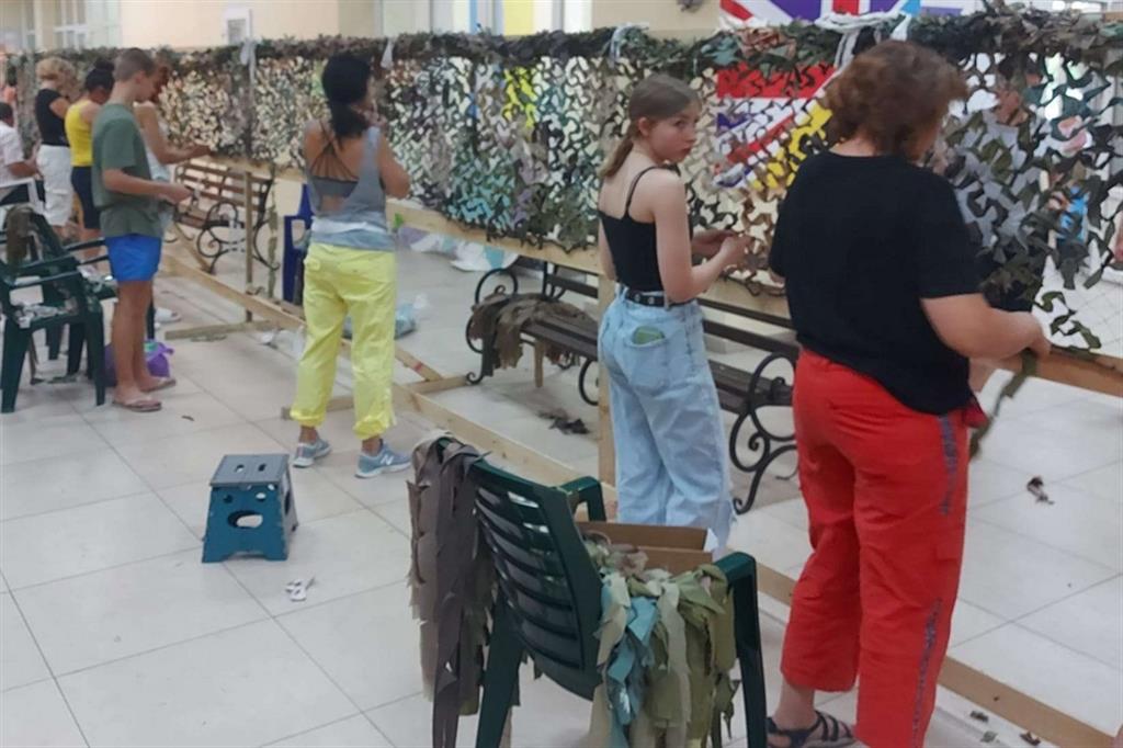 Volontari al lavoro nella fabbrica segreta allestita fuori Odessa per intrecciare le reti e cucire i teli mimetici
