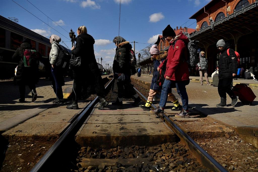 Profughi ucraini in Romania attraversano i binari ferroviari