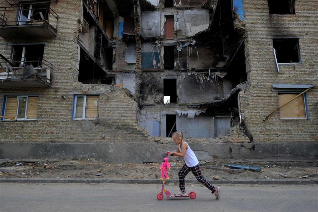 Una bambina tra le macerie della sua città distrutta