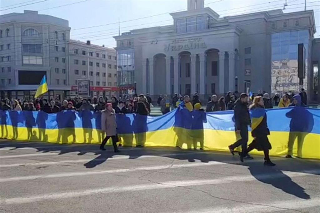La protesta dei cittadini di Kherson che hanno sfilato con una lunga bandiera ucraina contro l'occupazione russa