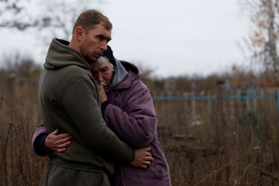 Mykola Melenets abbraccia la madre Nina durante la sepoltura del fratello, Oleksandr di 44 anni, morto sotto le bombe nel villaggio di Kamyanka vicino a Izyum, nella regione di Kharkiv