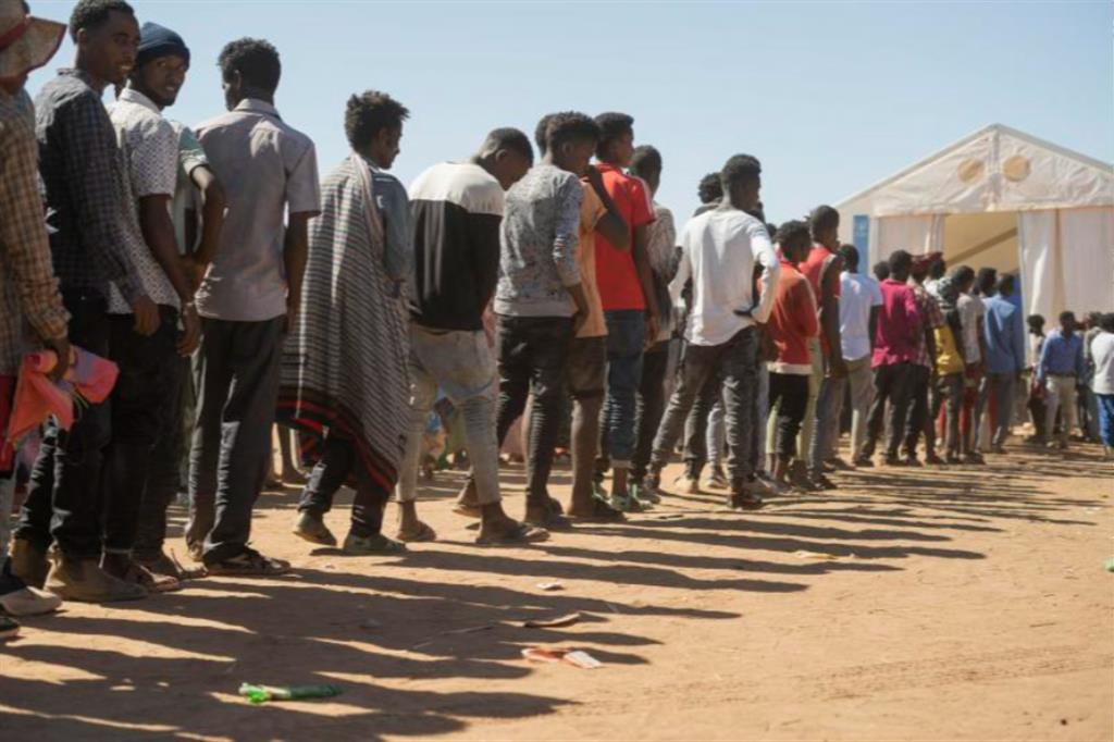 Rifugiati del Tigray in fila per il cibo in un campo in Sudan